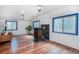 Bright living room with wood floors, ample natural light through the blue-framed windows, and wood burning stove at 1608 Beaver Brook Canyon Rd, Evergreen, CO 80439