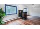 Living room featuring wood floors, blue-framed windows, and a charming, functional wood burning stove at 1608 Beaver Brook Canyon Rd, Evergreen, CO 80439