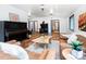Bright living room showcasing hardwood floors, a vintage piano, unique wood burning stove, and comfortable seating at 1608 Beaver Brook Canyon Rd, Evergreen, CO 80439