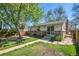 Beautiful backyard featuring lush trees, patio, grass, and a glimpse of home's exterior at 4781 S Grant St, Englewood, CO 80113