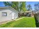 Backyard with detached garage, brick accents, patio area, and a grassy lawn at 4781 S Grant St, Englewood, CO 80113