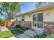Backyard patio with brick accents, bench seating, grass, and sliding glass door access at 4781 S Grant St, Englewood, CO 80113