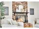 Cozy living room fireplace with brick surround, a black mantel, and a decorative mirror above at 4781 S Grant St, Englewood, CO 80113