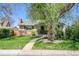 Charming front yard with a large mature tree, green lawn, brick accents, and a sidewalk pathway at 4781 S Grant St, Englewood, CO 80113