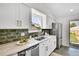Modern kitchen features stainless steel appliances, subway tile backsplash, and ample counter space at 4781 S Grant St, Englewood, CO 80113