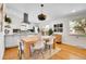 Open kitchen and dining area with modern lighting, stainless hood, and white cabinets at 4781 S Grant St, Englewood, CO 80113
