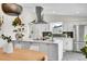 Bright kitchen featuring stainless hood, marble countertops, large island, and modern white cabinets at 4781 S Grant St, Englewood, CO 80113
