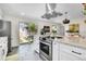 Well-lit kitchen with stainless appliances, marble countertops, and sliding glass doors to yard at 4781 S Grant St, Englewood, CO 80113