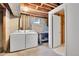 Unfinished laundry room with workbench, unfinished ceiling, and washer/dryer units at 4781 S Grant St, Englewood, CO 80113