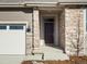 Front entrance with stone facade, dark door, and covered porch at 1927 S Coolidge Way, Aurora, CO 80018