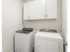 Laundry room with washer, dryer, and overhead cabinets at 1927 S Coolidge Way, Aurora, CO 80018