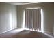 A bedroom with neutral walls and carpet with a large window covered with curtains at 8603 E Dry Creek Rd # 211, Englewood, CO 80112