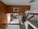 Looking down from an interior balcony to the kitchen, stairs on the right, and wood paneled walls at 6720 W 112Th Pl, Westminster, CO 80020
