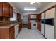 A full kitchen featuring wood cabinetry, laminate countertops, and a full suite of appliances at 6720 W 112Th Pl, Westminster, CO 80020