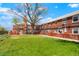 Exterior shot of a brick townhouse building with a large tree in the yard at 2813 Jasmine St, Denver, CO 80207