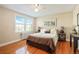 Spacious bedroom featuring a comfortable bed, large window, and hardwood floors at 2813 Jasmine St, Denver, CO 80207