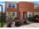 Charming brick townhouse with manicured landscaping, and a walkway to the front door at 2813 Jasmine St, Denver, CO 80207