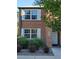 Classic brick townhouse features updated windows with white shutters, and manicured shrubs at 2813 Jasmine St, Denver, CO 80207