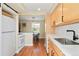 Charming kitchen with stainless steel sink, light wood cabinets, and an open view to the dining area at 2813 Jasmine St, Denver, CO 80207
