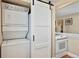 Convenient laundry setup with stacked washer/dryer and adjacent kitchen appliances behind a modern sliding door at 2813 Jasmine St, Denver, CO 80207