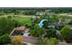 Aerial view points to the house with green lawn and mature trees nearby fields and buildings at 117 Sandler Dr, Lafayette, CO 80026