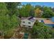 Aerial view of the sage green home with solar panels, landscaping and raised garden beds at 117 Sandler Dr, Lafayette, CO 80026