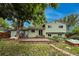 Exterior rear view of a sage green home with a brick patio and a beautiful green lawn at 117 Sandler Dr, Lafayette, CO 80026