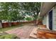A stone patio is bordered by trees and planter boxes in this home's lovely backyard at 117 Sandler Dr, Lafayette, CO 80026