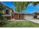 Charming home featuring a red door, brick accents, well-maintained lawn, and mature trees at 117 Sandler Dr, Lafayette, CO 80026