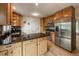 Modern kitchen featuring a stainless steel refrigerator, granite countertops, and wood cabinets at 117 Sandler Dr, Lafayette, CO 80026
