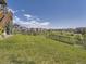 Spacious backyard featuring a lush lawn, black metal fence, and a view of the surrounding neighborhood at 11096 Endeavor Dr, Parker, CO 80134