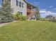 A view of the two story house with a backyard with wooden steps leading to a covered deck at 11096 Endeavor Dr, Parker, CO 80134