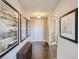 Inviting hallway with dark wood floors, neutral walls, decorative art, and a view of the front door at 11096 Endeavor Dr, Parker, CO 80134