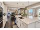 Bright, open kitchen with white cabinetry, island, stainless steel appliances, and view into the living room at 11096 Endeavor Dr, Parker, CO 80134