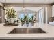 Kitchen island with stainless steel sink, quartz countertop, pendant lighting, and an open view of the house at 11096 Endeavor Dr, Parker, CO 80134