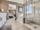 Main bathroom showcasing a soaking tub, glass shower, neutral design and access to the main bedroom at 11096 Endeavor Dr, Parker, CO 80134