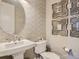 Stylish powder room featuring decorative wallpaper, mirror, pendant sink, and modern toilet at 11096 Endeavor Dr, Parker, CO 80134