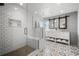 Modern bathroom with a tiled shower, double vanity, and decorative patterned floors at 8783 S Carr Way, Littleton, CO 80128