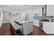 Bright kitchen with a gray island, stainless appliances and a blue tiled backsplash at 8783 S Carr Way, Littleton, CO 80128
