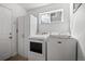 Modern laundry room with front-load washer and dryer, storage cabinet, and window at 8783 S Carr Way, Littleton, CO 80128