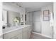 Bright bathroom with double sink vanity, a modern shower with glass doors, and stylish fixtures at 2620 S Delaware St # 3, Denver, CO 80223