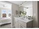 A bathroom featuring a double sink vanity, next to a bedroom with a balcony and great natural light at 2620 S Delaware St # 3, Denver, CO 80223