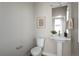 Clean powder room with a pedestal sink, toilet, and tasteful decor, offering a convenient and stylish space at 2620 S Delaware St # 3, Denver, CO 80223