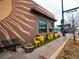 The storefront of Maria Empanada, with a decorated exterior and outdoor seating for dining at 2620 S Delaware St # 3, Denver, CO 80223