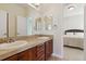 Bathroom featuring a double vanity with granite countertops, wood cabinets, mirrors, and tile flooring at 4619 Mohawk Dr, Larkspur, CO 80118