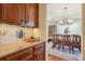 Butler's pantry area with granite countertops, wooden cabinets, and access to the dining room at 4619 Mohawk Dr, Larkspur, CO 80118