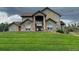 Stunning two-story home featuring a beautiful stone entrance and a lush green front lawn at 4619 Mohawk Dr, Larkspur, CO 80118