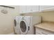 Laundry room featuring modern front-load washer and dryer with countertops and upper cabinets at 4619 Mohawk Dr, Larkspur, CO 80118