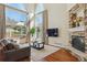 Bright living room featuring floor-to-ceiling windows, a fireplace, and hardwood floors at 4619 Mohawk Dr, Larkspur, CO 80118