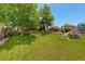 Expansive backyard with lawn, shade trees, and a play structure at 12671 Meadow Bridge Way, Parker, CO 80134